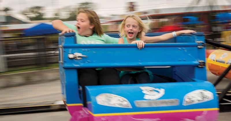 two kids screaming as they ride the scrambler